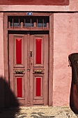 Rosa Fassade mit alter Haustür in rosa und rot gestrichen