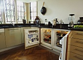 Moderne Küche mit geöffneten Kühlschranktüren unter Arbeitsplatte