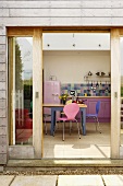 Blick durch offene Terrassentür in moderne Küche mit Essplatz