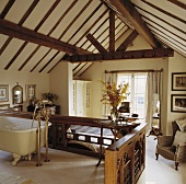 Dachraum mit spitz zulaufendem Dachgewölbe und offenem Bad mit Clawfoot Badewanne