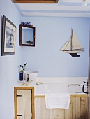 Badezimmer mit rustikaler Holzverkleidung in pastellblau und mit Meeresmotiven dekoriert