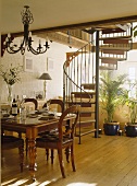 Speisesaal mit einer modernen Wendeltreppe, einem Holzboden, mit einem viktorianischen Tisch und mit viktorianischen Stühlen ausgestattet