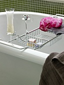 Badewanne mit Badewannenablage und ein Glas Champagner