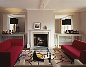 A living room in a period building with a fireplace and furniture in a mixture of styles from Bauhaus to modern