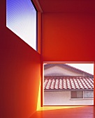 Neubauhaus mit leerem Raum rot gestrichen und raumhohem Fenster