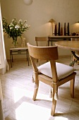 Holzstuhl mit weißem Sitzkissen in einem Esszimmer mit Holzboden