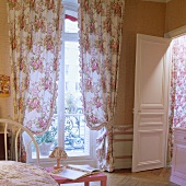 Vorhänge mit Blumenmuster vor französischem Fenster im Schlafzimmer