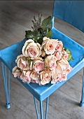 A bunch of pink roses in a blue stool