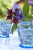Blüten in blauen Gläsern als Tischdeko