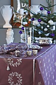 A wall table decorated for Christmas with a Christmas tree next to it