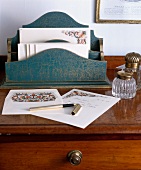 Antikes Schreibtisch-Ambiente mit Briefständer aus Holz und geöffnetem Füller auf Briefpapier mit Paisley-Muster