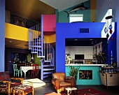 Wohnzimmer, Esszimmer, Küche und eine Wendeltreppe in einem offenen Wohnraum mit bunten Farben