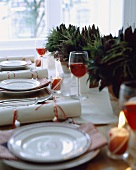 Weihnachtlich gedeckter Tisch mit rot-weiss gestreiften Kerzen