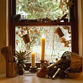 Verschwommener Blick aus Schiebefenster in braunem Holz mit Tannenzapfen, Kupferkännchen und Kerzen dekoriert