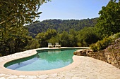 Geschwungenes Swimmingpool mit Liegen von niedrigen Bäumen umgeben in Südspanien