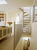 Wendeltreppe führt aus modernem Wohnzimmer zu weißem Podest