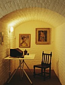 Tisch und Stuhl im Keller Studio mit Bildern an der Wand