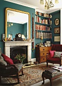 Großer vergoldeter Spiegel über Marmorkamin im grünen Stadthaus Wohnzimmer mit Bücherregalen und antiken Möbeln