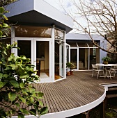 Ein architektonisches Haus mit einer gebogenen Dachterrasse, die zum privaten Gartenbereich ausgerichtet ist