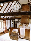 Ein Bett mit diversen Kissen, das im Dachgeschoss eines Fachwerkhauses steht