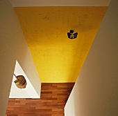 Blick hinunter auf der modernen Halle mit einer grob verputzten gelben Wand und einen Parkettboden