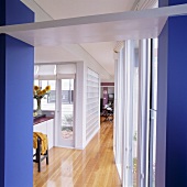 Gangflucht mit Holzparkett, blauen Wänden und Wand aus Glasbausteinen in modernem Haus