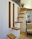 Treppenstufenartig angebrachte Holzborde an gebogener Wand mit Fensterschlitzen in traditionellem Wohnzimmer