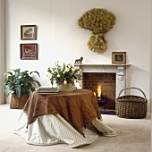 Ein runder Tisch mit Paisley Tuch vor dem Kamin in einem Wohnzimmer