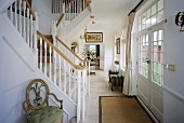 Grosse weiße Halle mit halb verglasten Türen und im Regency-Stil gebauter Treppe