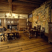 Großer Rittersaal mit hängendem Wandteppich, Holzmöbeln und Holzdielen