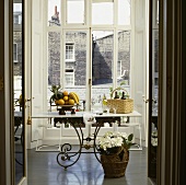 Ein Tisch mit Marmorplatte und schmiedeeisernen Füssen am Fenster im Esszimmer