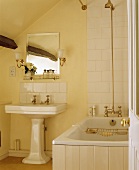 Badezimmer mit hellen Fliesen und Wänden im Dachgeschoss