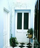 Südländisches Flair im Hauseingang mit türkis farbenen und bemalten Wänden mit Glyzinienmotiven