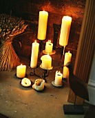 Kerzenlichtstimmung mit verschiedenen weissen Kerzen vor Steinwand