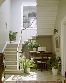 Klavier und Zimmerpflanzen unter der Treppe in einer georgianischen Halle
