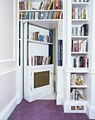 weiße Bücherregale, die Tür auch als Regal getarnt