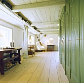 Holzdielen und grüne Wandschränke in einem ländlichen Wohnzimmer