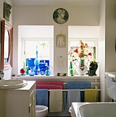 Bad mit Handtüchern auf Heizungsrohren unter Fensterbank mit Glaswaren