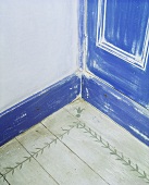 Zimmerecke mit blauer Bemalung und Dielenboden mit Schablonenbemalung