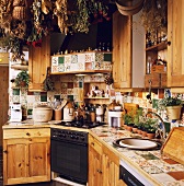 Landhausküche mit Holzfronten und getrockneten Blumen unter der Decke