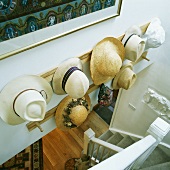 Weisses Treppenhaus mit Hutsammlung an Wand