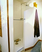 Bad mit weißem abgetrenntem Duschbereich und Kopfbrause