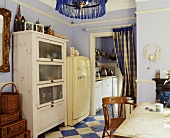 Küche im Stilmix mit violetter Wand und blau weißem Schachbrettmuster auf Boden