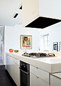 A white kitchen counter with an extractor fan