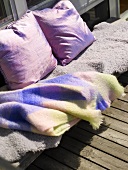 A blanket and cushions on a balcony