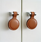 Cupboard handles made of metal and leather