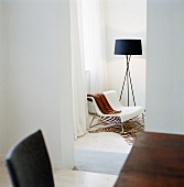 A view of chair on a zebra rug next to a floor lamp