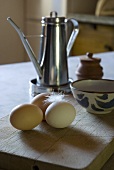 Fresh eggs and a feather on a wooden table