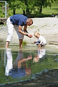 Vater und kleine Tochter spielen im See