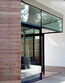 Corner of a house with a glass facade and open patio door